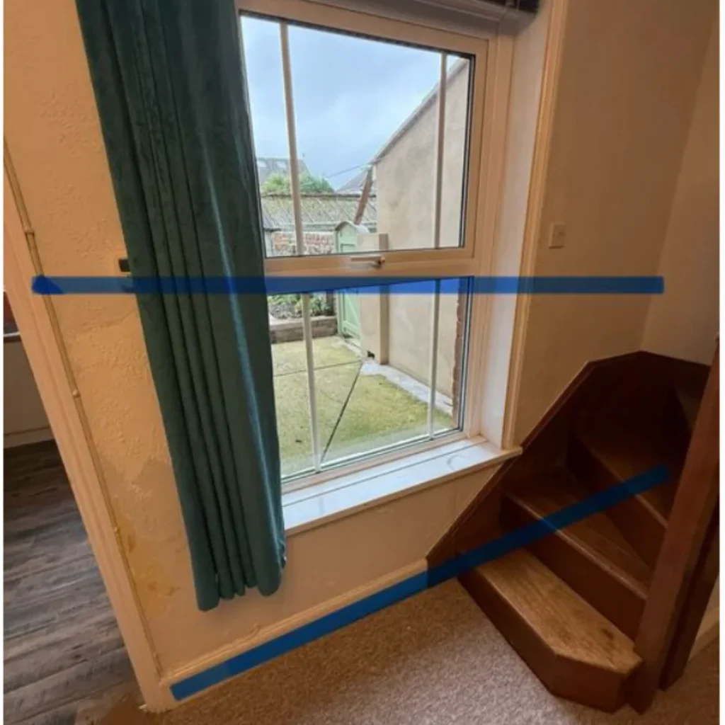Internal ground floor window area showing visible damp staining and moisture tracking during a professional damp inspection.