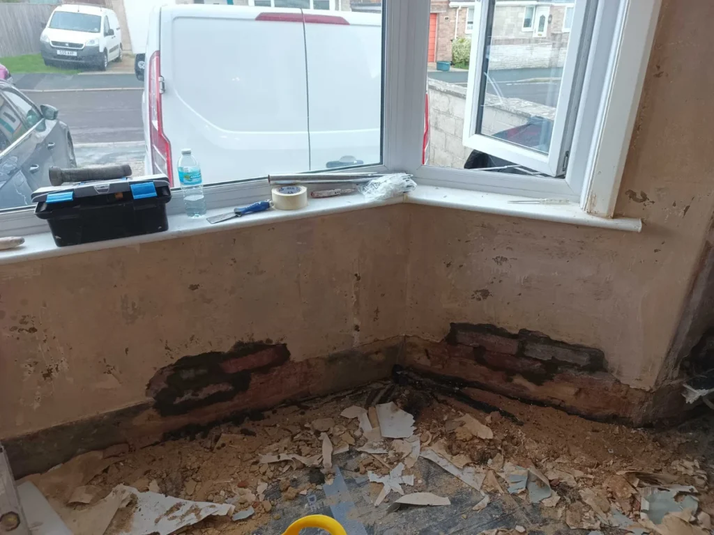 Corner wall stripped back to brick for rising damp treatment