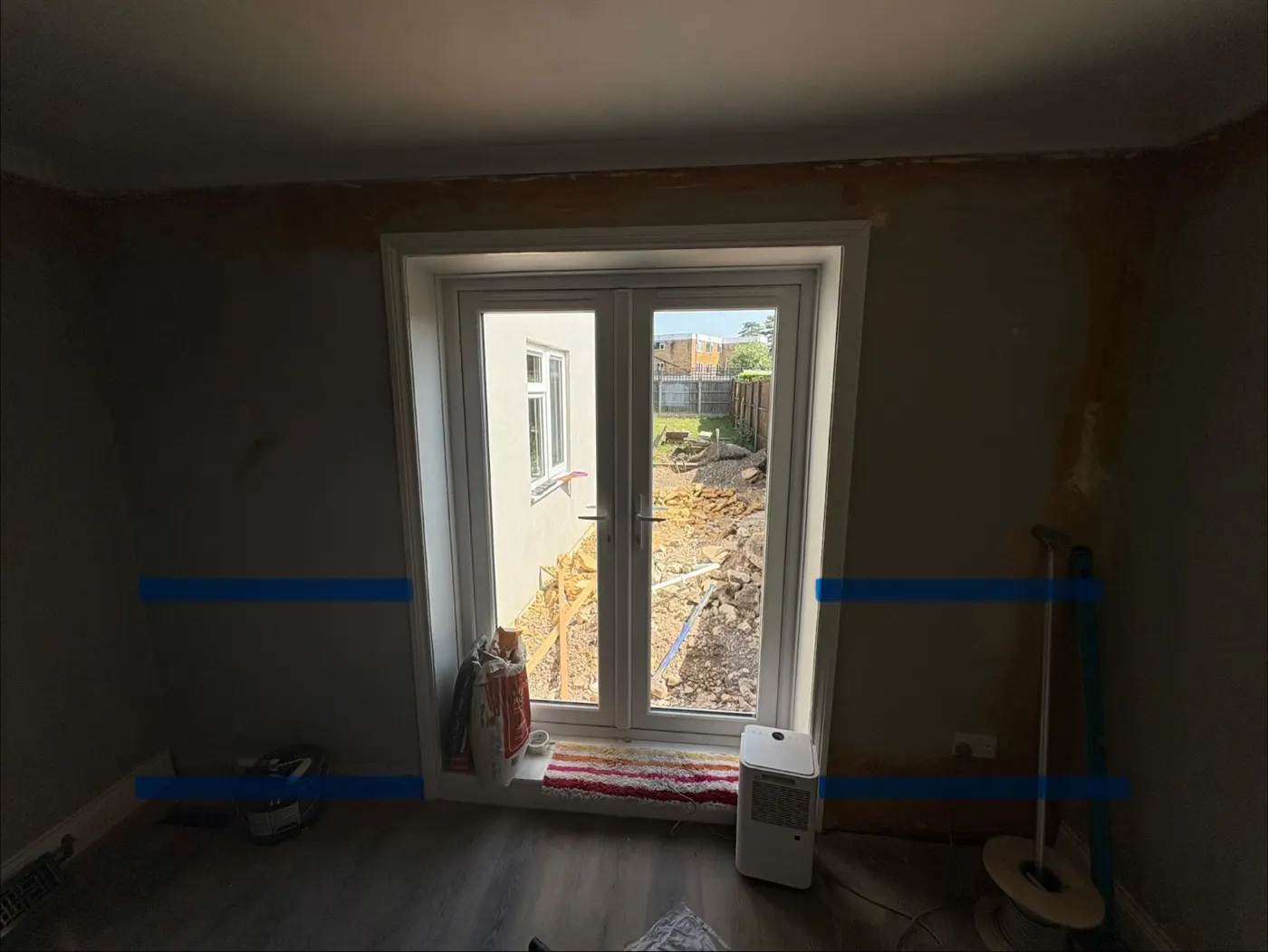 Dining room in a Salisbury home with damp walls marked in blue tape up to one metre