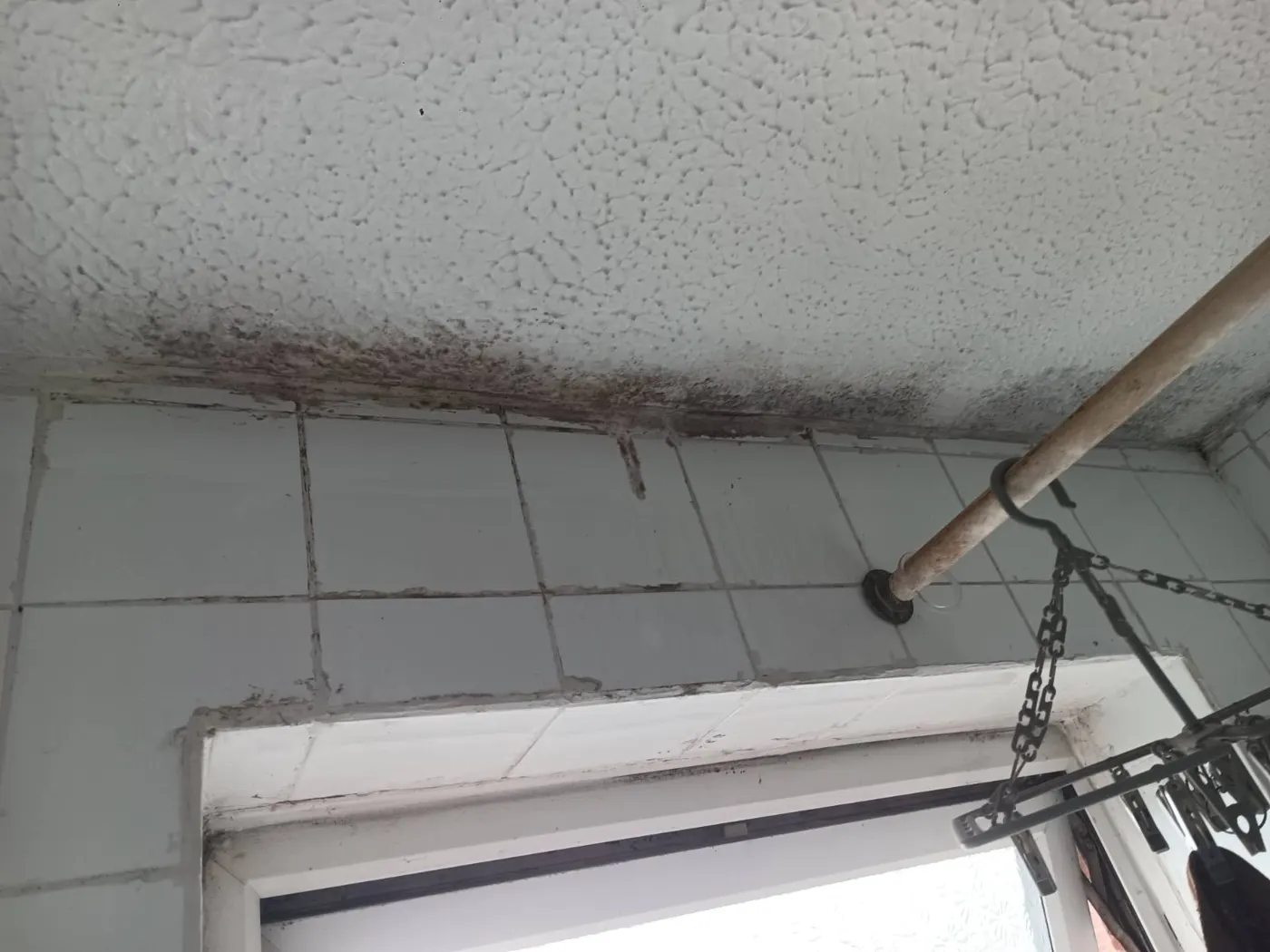 Mould on a bathroom ceiling around the window caused by condensation and poor extraction