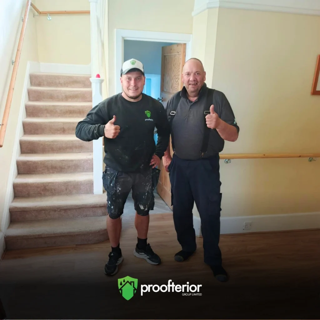 Proofterior damp proofing specialist with Hampshire homeowner after completed wall treatment in hallway.