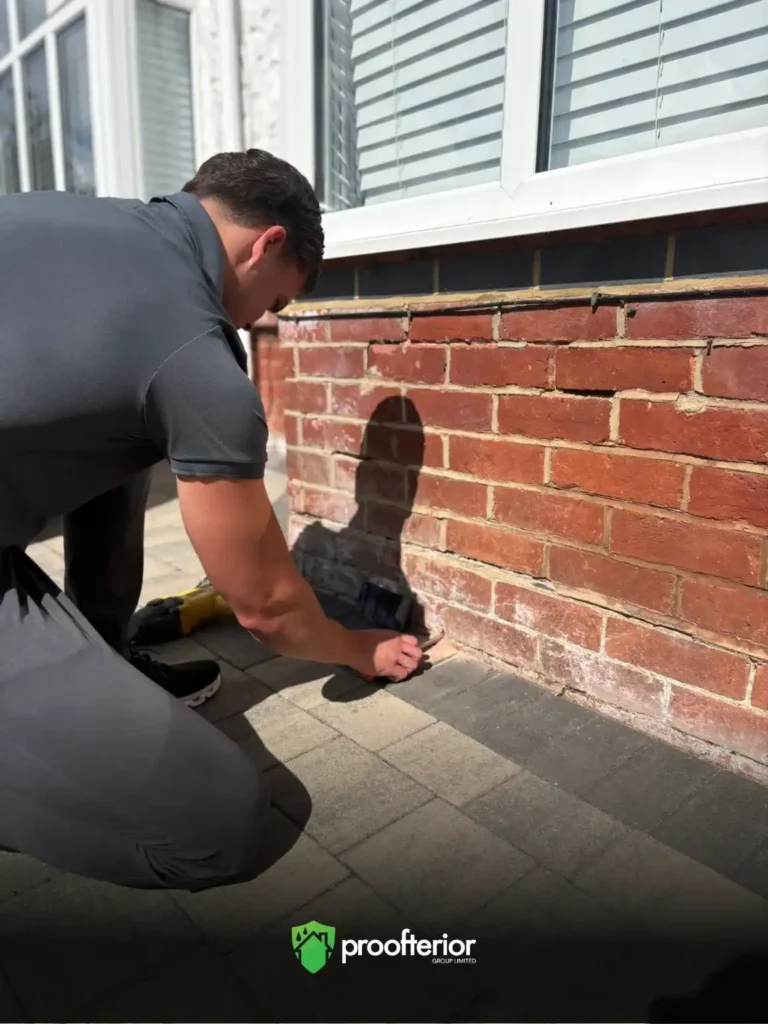 Proofterior damp specialist inspecting external brick wall for rising damp in Hampshire home