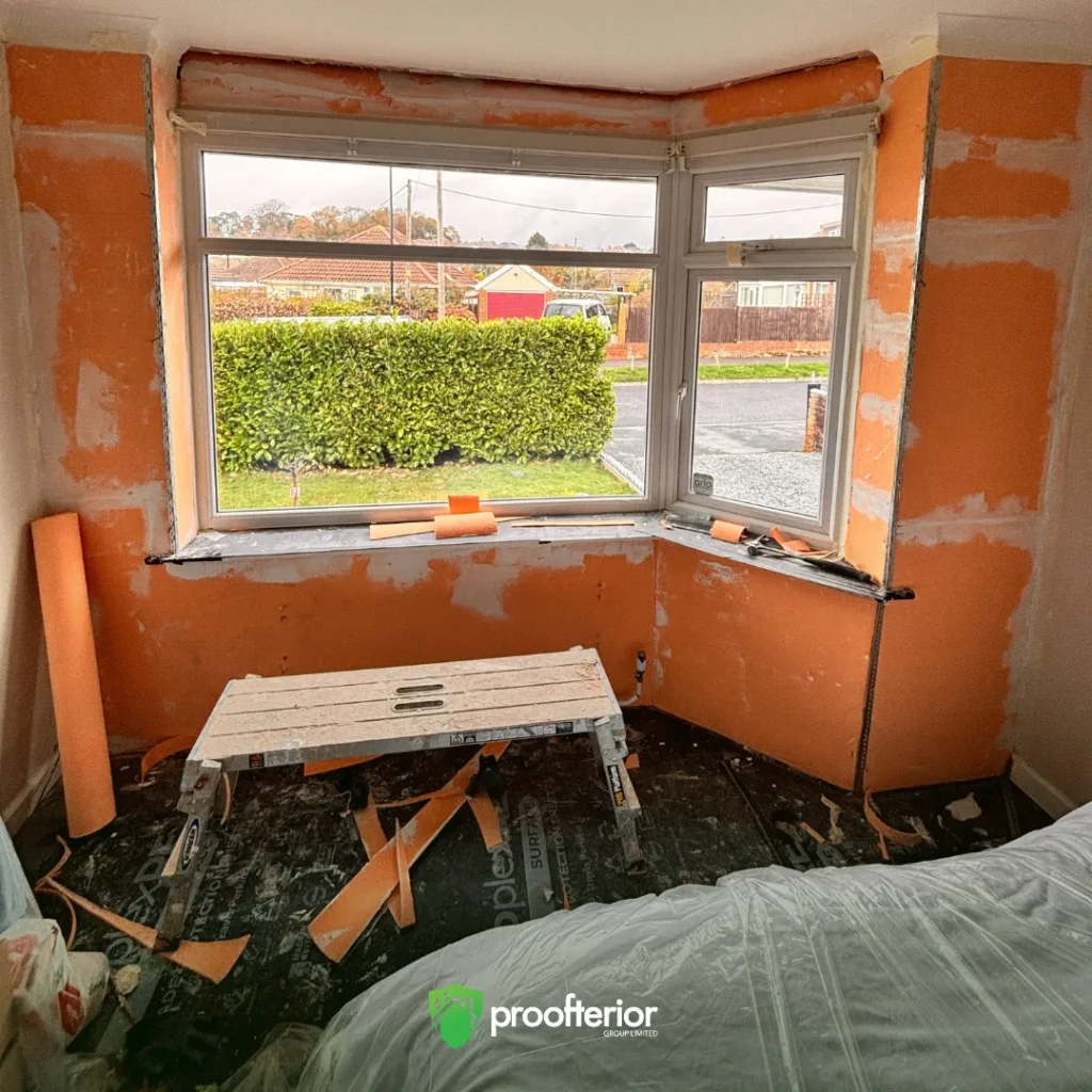 Southampton bedroom during Iso-Therm insulation installation with orange insulation panels applied to cold external walls.