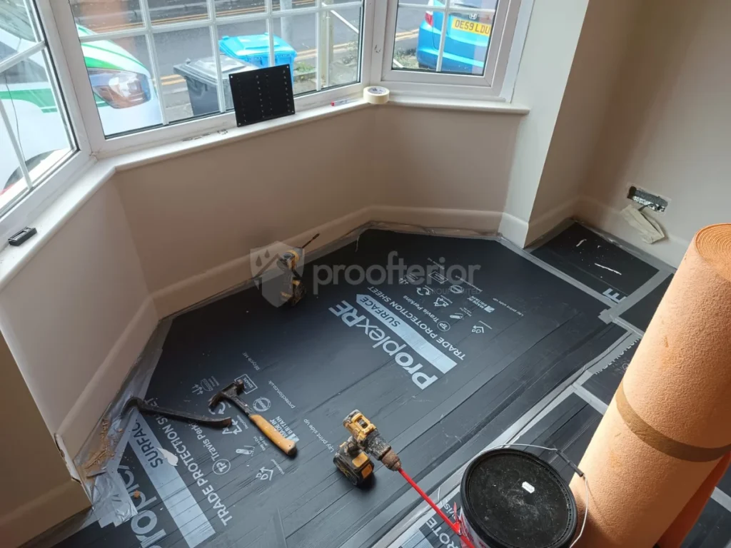Bedroom floor protected with Proplex trade protection sheets during an internal wall insulation installation in a Bournemouth home.