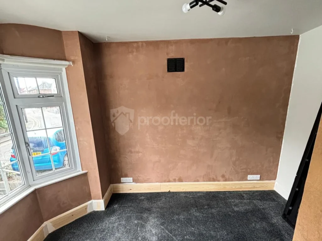 A bedroom wall in Bournemouth fully prepped with internal insulation boards and base-coat plastering for a mould-free finish.
