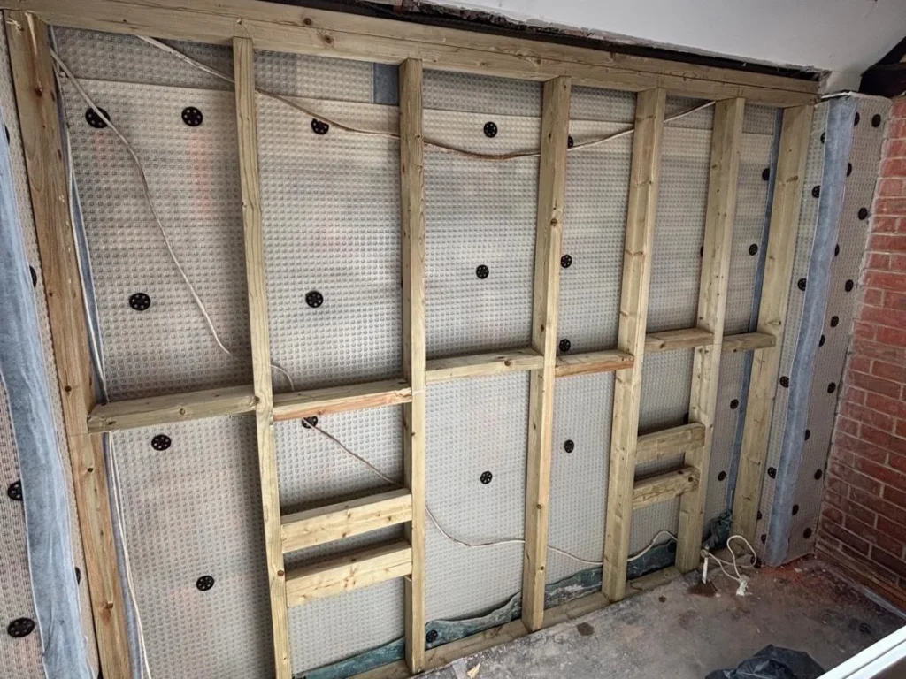 timber stud framework installed over damp proof membrane system on retaining wall in Wimborne for internal waterproofing solution
